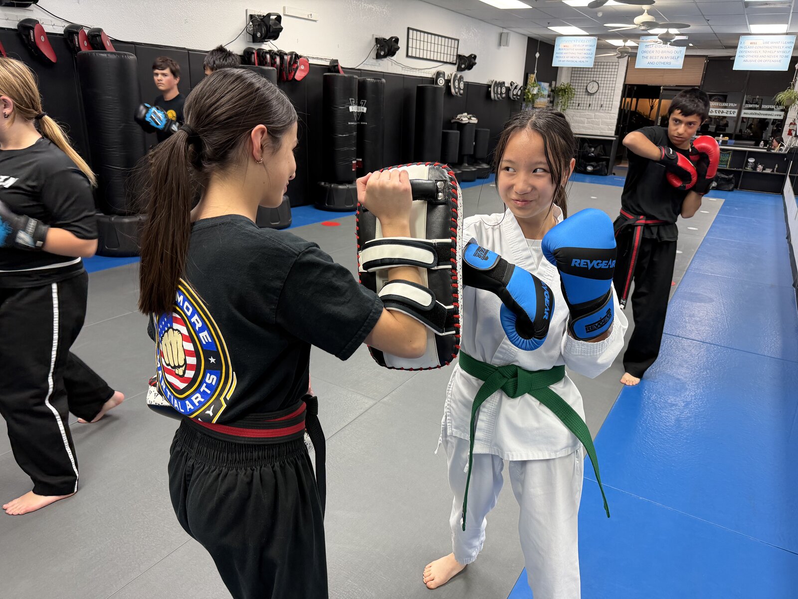 Junior martial arts students practicing pad drills at the academy